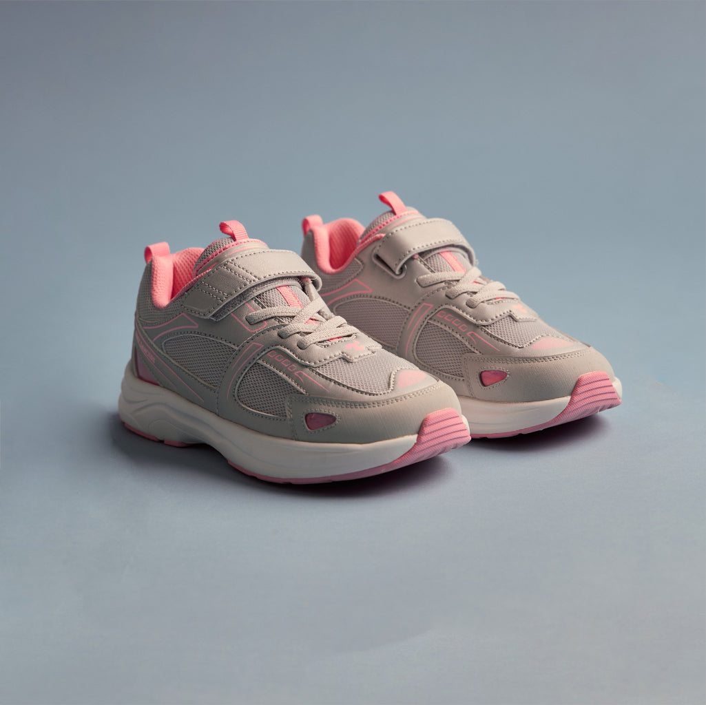 A pair of Play Junior in silver pink, three-quarter view on a soft blue background.