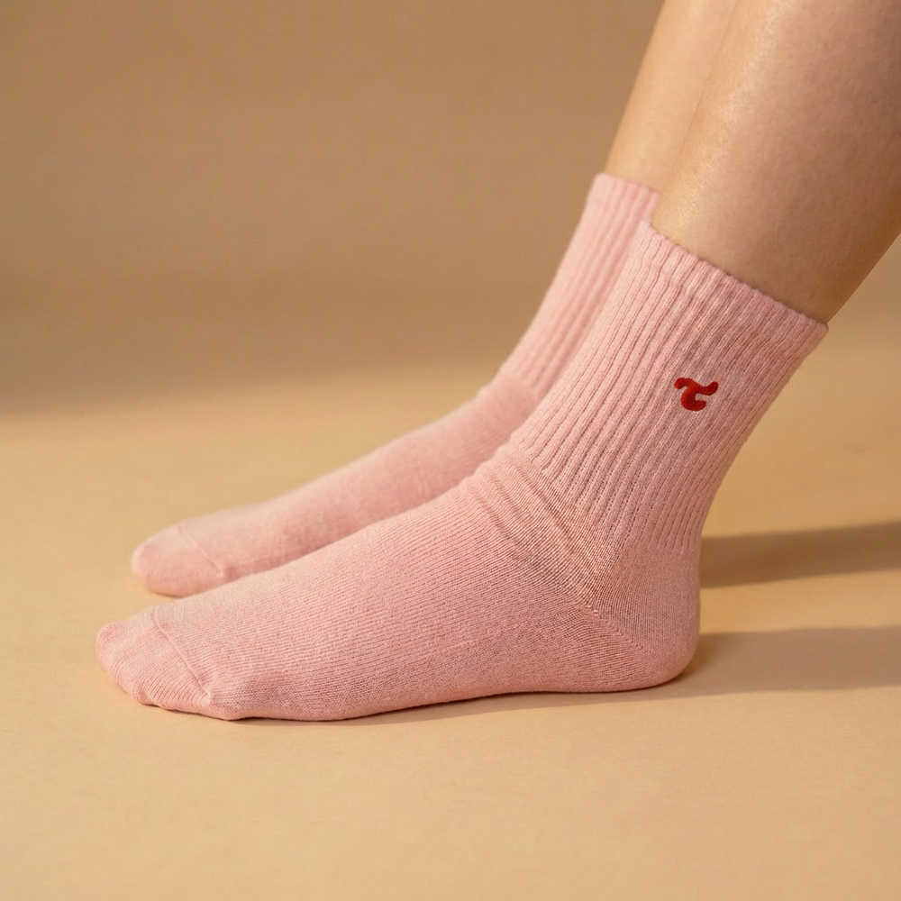 A single Tiny Socks sock in Barely Pink worn on a foot.