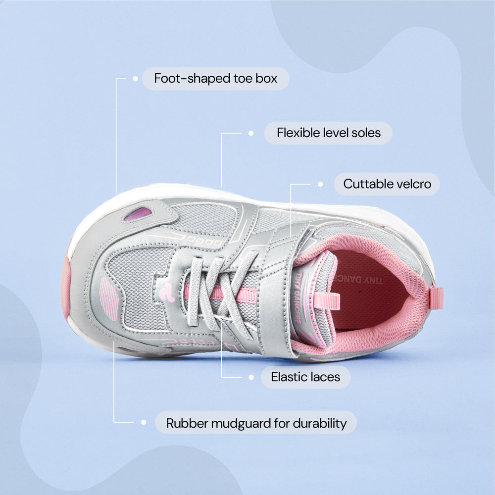 Play Junior in silver pink from above, labelled: foot-shaped toe box, flexible level soles, cuttable velcro, elastic laces, rubber mudguard.