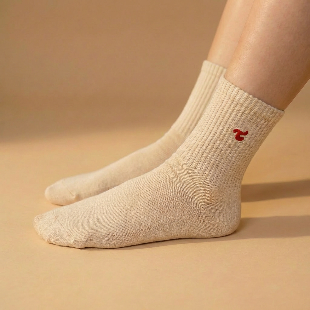 A single Tiny Socks sock in Sugar Swizzle worn on a foot.