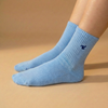 A single Tiny Socks sock in Soft Marina worn on a foot.