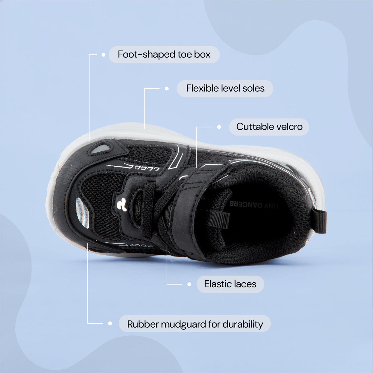 Play Infant in black from above, labelled: foot-shaped toe box, flexible level soles, cuttable velcro, elastic laces, rubber mudguard.