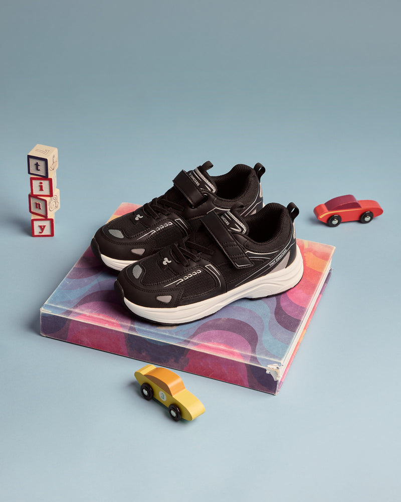 A pair of Play Junior black on a marbled plinth with wooden tiny blocks and toy cars.